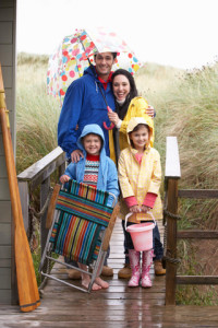  une famille avec 2 enfants sourient malgré le tempps pluvieux qui aurait dû gâcher leur promenade au bord du lac
